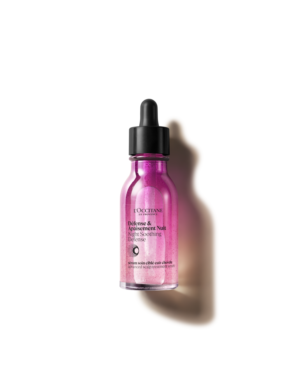 A bottle of pink liquid on a white surface