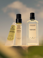 L'Occitane Verveine products including a bottle, spray, and cream against a blurred natural background.